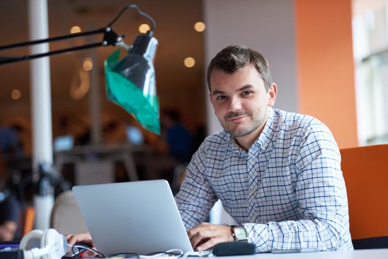 Business man working at his desk and smiling to the camera